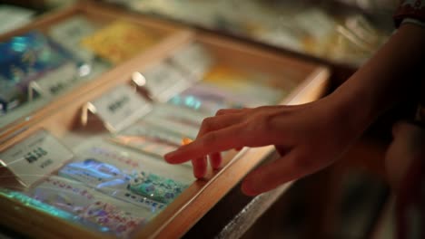 hand reaching into display case of japanese souvenirs