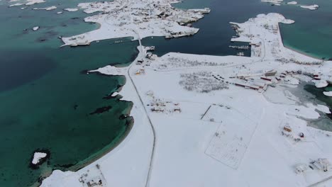 drone view in tromso area in winter flying over a snowy flat islands connected by bridges with small towns in norway