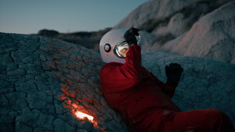 lone astronaut prepares for the night in a mountain of a hostile planet