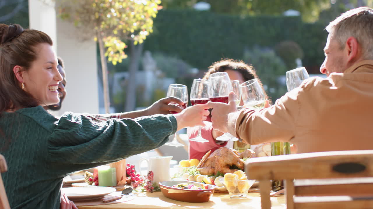 다양한 행복한 남녀 친구들이 빛 정원에서 축하 식사를 하고 있습니다.