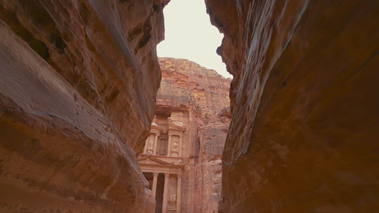 caminando hacia el tesoro a través de la siq en petra, sitio histórico del patrimonio de la unesco tallado en piedra arenisca en jordania. famoso indiana jones última cruzada lugar de filmación y destino turístico khaznet. disparo revelador.