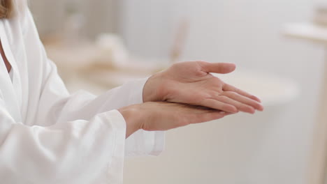 woman applying hand cream or skincare product