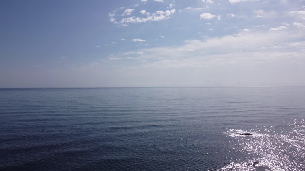 Aerial drone above sea water, clear skyline light clouds formation, drone video