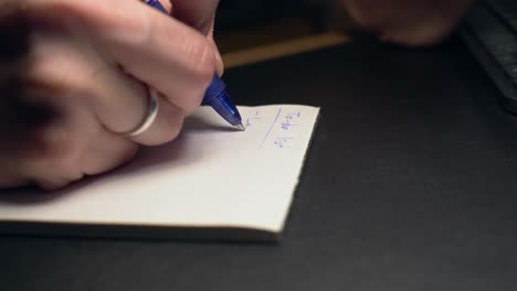 Extreme-closeup-shot-of-male-hand-taking-notes-on-paper