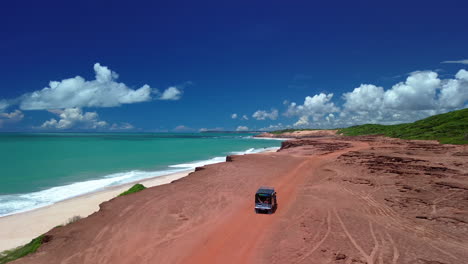 drone siguiendo un automóvil fuera de carretera que conduce en la costa de chapadao, brasil