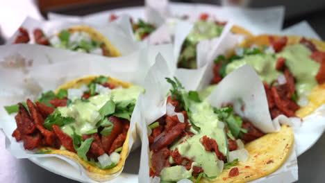 slow motion savory look at street tacos with guacamole sauce on a plate - food truck series