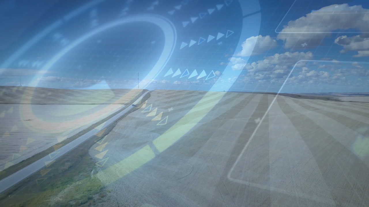 Striped farmland stretching toward horizon while angled road running through animated HUD overlay