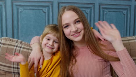 Child-kid-daughter-with-mother,-embracing,-waving-hands-to-camera-doing-hello-welcome-or-bye-gesture