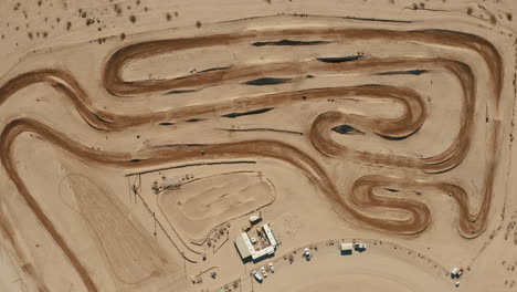 circuito de tierra de motocross durante la carrera, vista aérea alta desde arriba acercándose