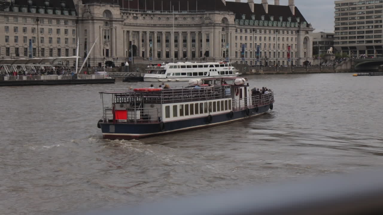 Passenger Boat going down the river Thames in London UK day time.