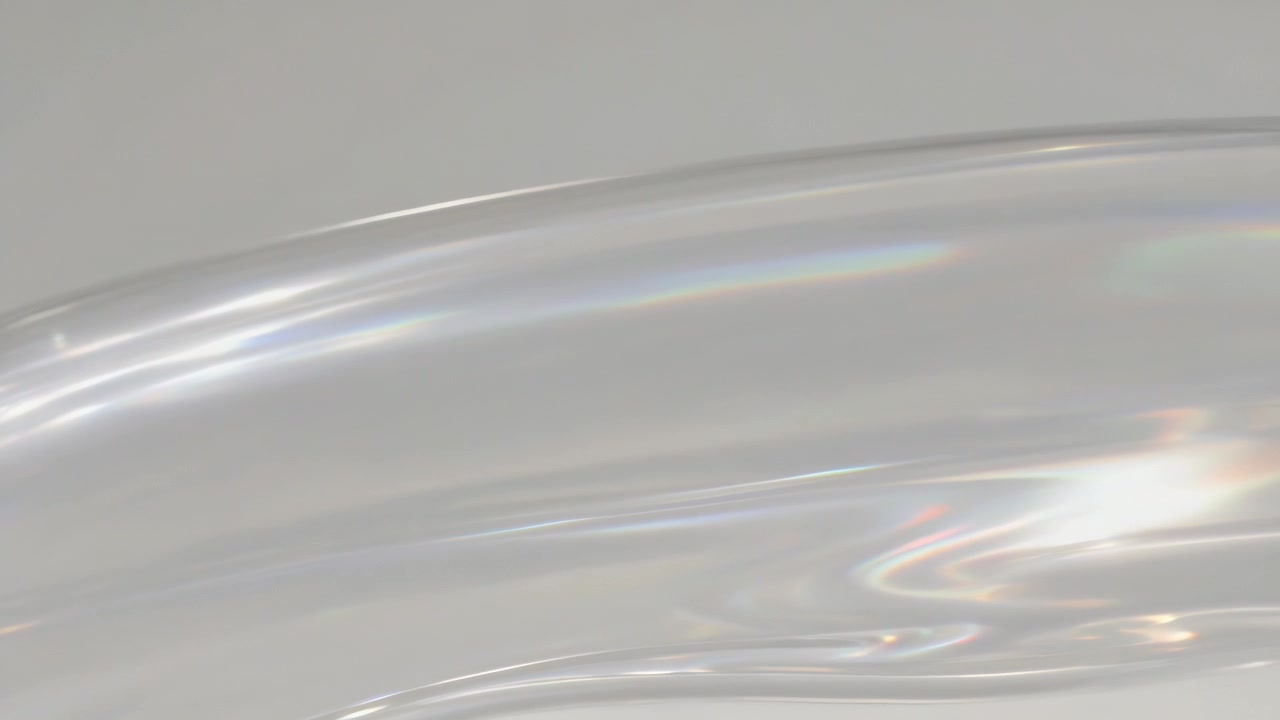 Shifting camera and light revealing clear glass rim on grey backdrop, showing rainbow refractions