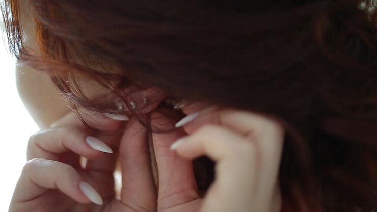 Woman Putting on Earrings