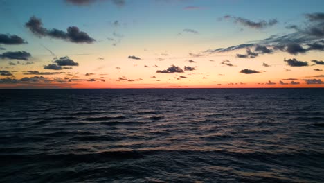 puesta de sol dorada tropical sobre el agua del océano vista aérea en cámara lenta