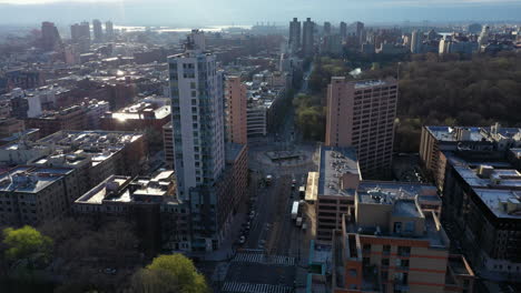 épico sobrevuelo lento de harlem nyc highrise al amanecer con bengalas de sol fuera de los edificios
