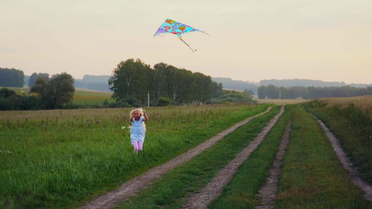 Happy Little Girl Running with a Kite in a Green Field at Sunset