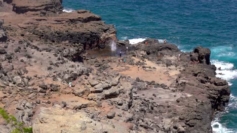 naklele blowhole exploding on the rocky cliffs with pacific ocean in the background on maui, hawaii, united states