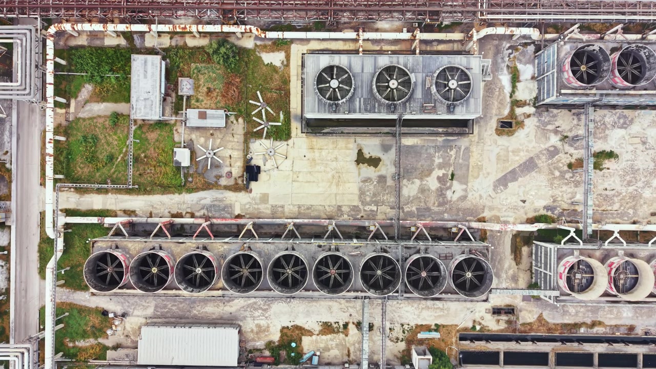 View of an industrial area with large cooling fans and equipment taken from above during daylight hours