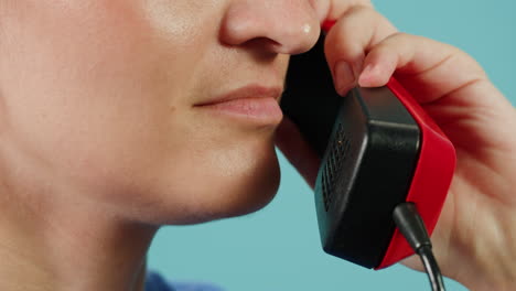 woman talking on a vintage red telephone