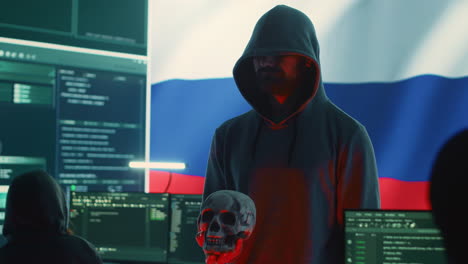 Digital-outlaw-hacker-in-a-dark-hood-issuing-cyber-threats-with-a-human-skull