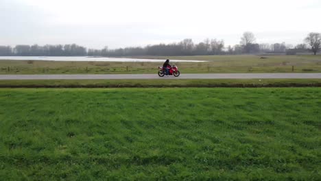 Drone-shot-of-a-motorcyclist-standing-still-in-the-middle-of-the-road