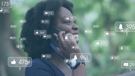 Animation-Von-Mediensymbolen-über-Einer-Afroamerikanischen-Frau,-Die-Auf-Dem-Smartphone-Spricht