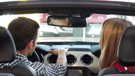 una pareja feliz sonriendo alegremente mostrando las llaves del coche de su nuevo conferible
