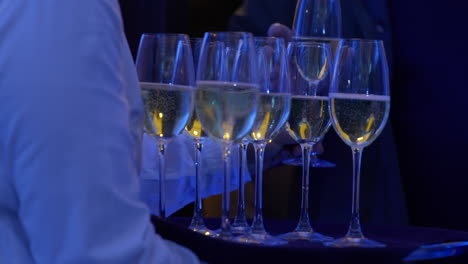 Waiter-giving-out-champagne-glasses-to-guest-during-event-night,-slow-motion