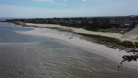 una vista aérea de las aguas, frente a una playa vacía en un día soleado de verano