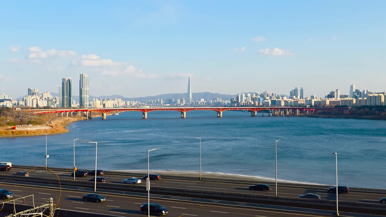 Zoom in tempo reale sul traffico dell'autostrada Gangbyeonbuk-ro verso il Ponte Seongsu e la Lotte World Tower attraverso il fiume Han a Seul