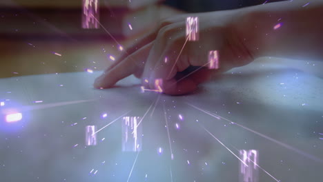 glowing pink particles floating against close up of a hand reading a book in braille