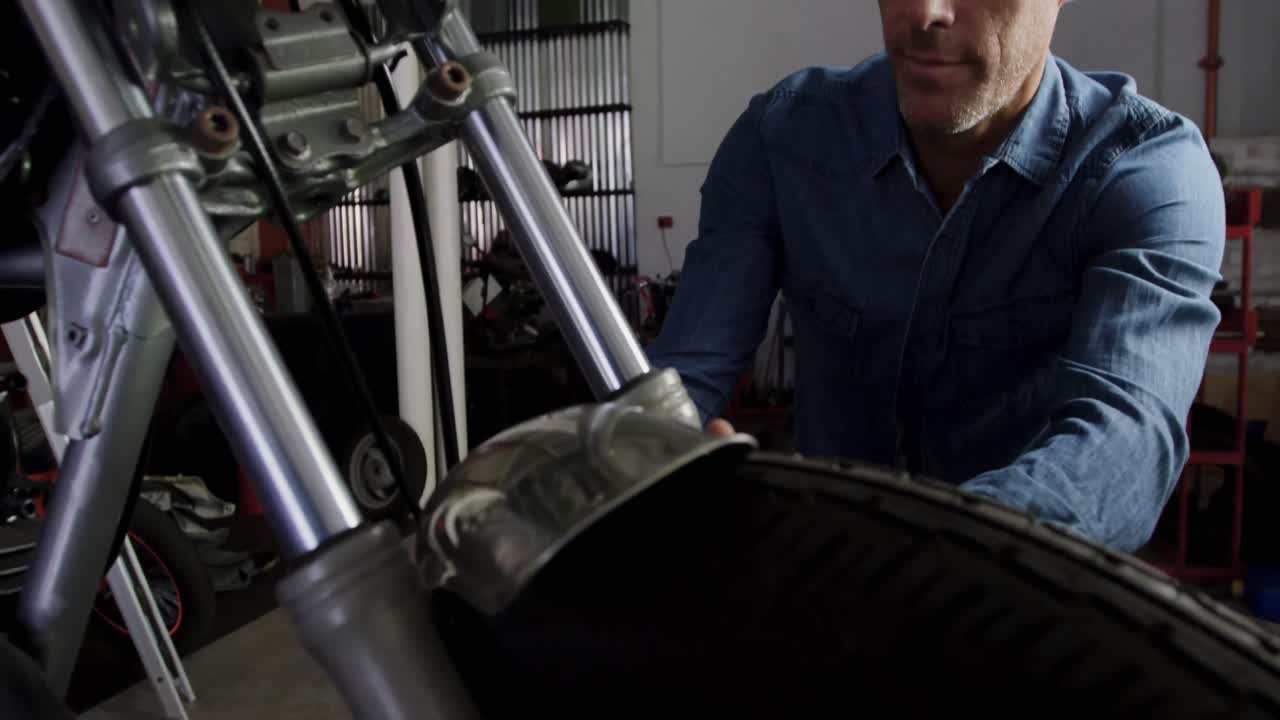 mecánico masculino reparando motocicletas en el garaje de reparación 4k