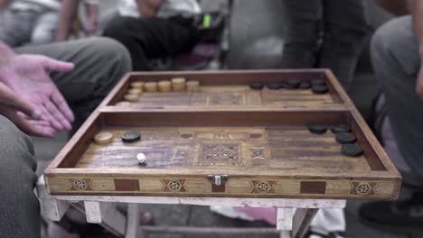 crop indigenous men playing backgammon on street