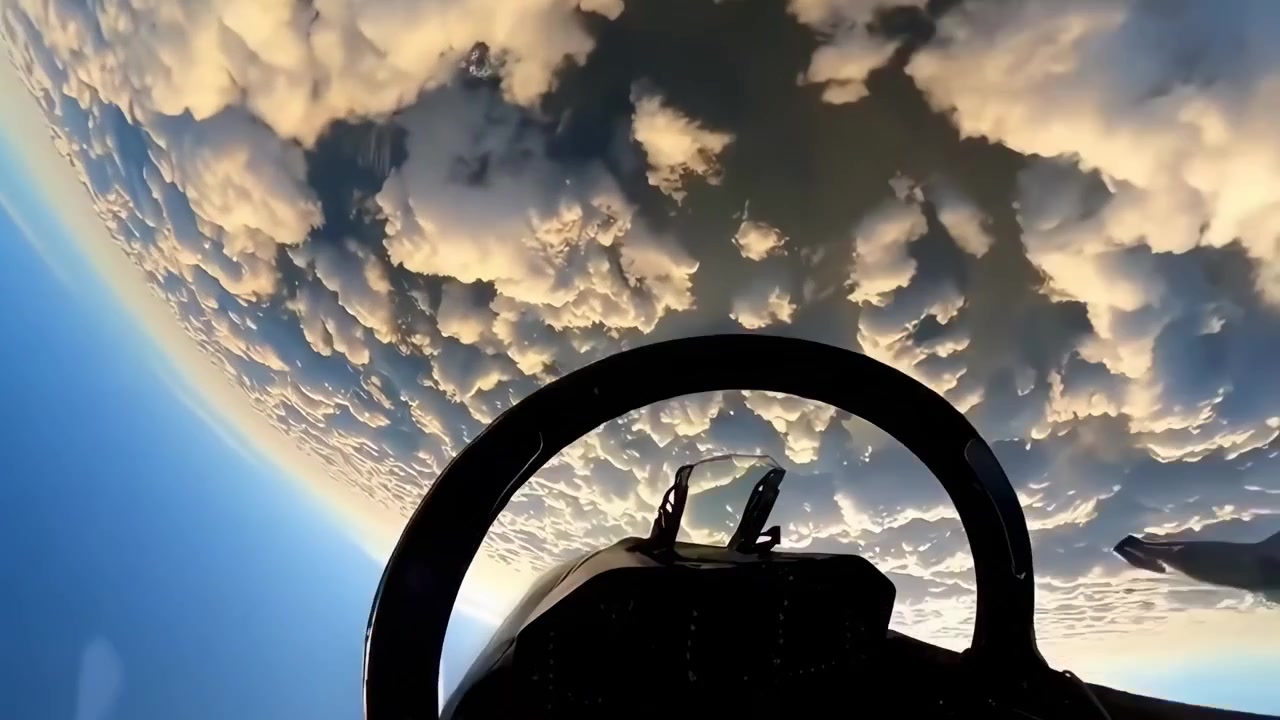 Pilota di jet da combattimento che esegue una manovra aerea sopra le nuvole