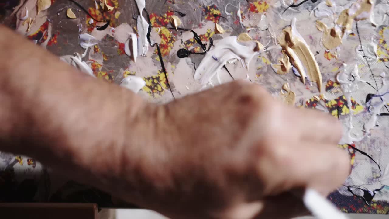 Artista che dipinge su tela con colori multicolori.