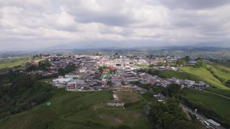 vista aérea de la ciudad de filandia en la cima de una colina rodeada de campos verdes, ubicada en el lado oeste de la cordillera central de la cadena montañosa de los andes.