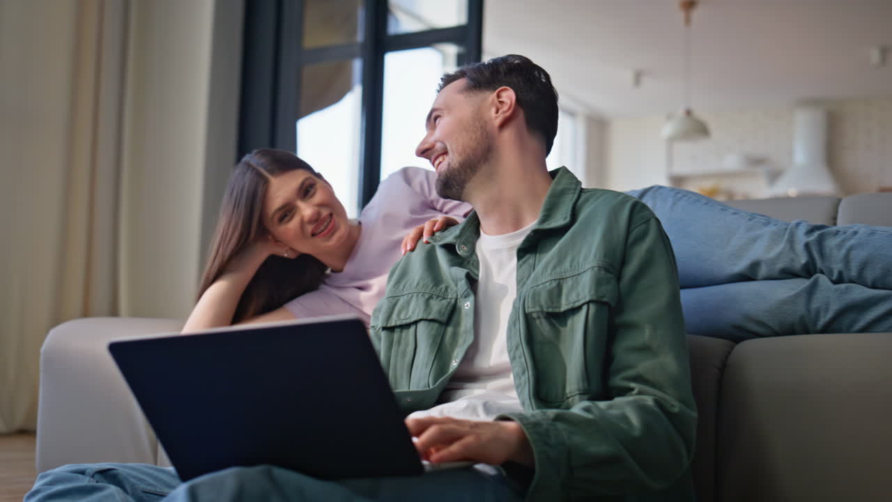 Emotional soulmates watching computer discussing home closeup. Couple laughing