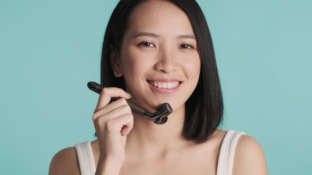 얼굴을 마사지하는 아시아 여성.