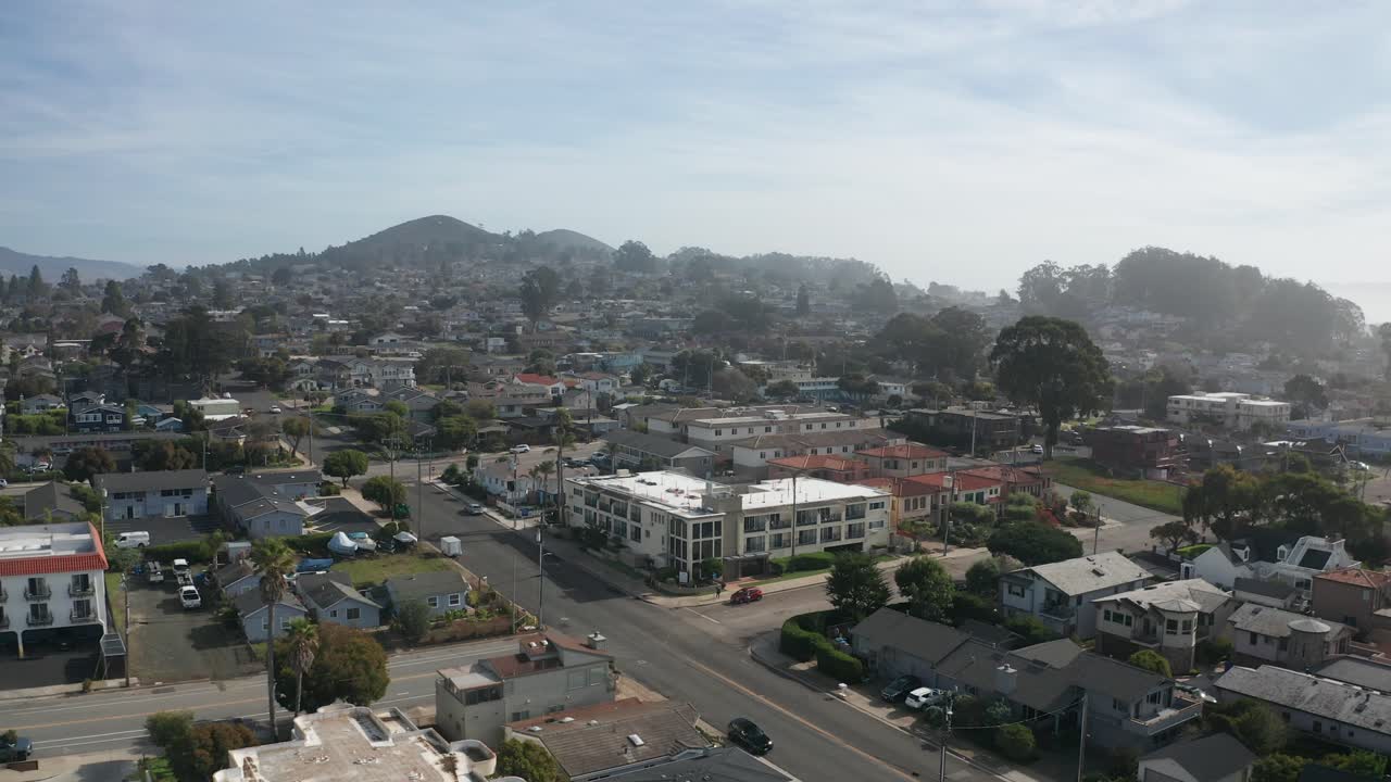 Aerial wide reverse pullback shot of Morro Bay along the Central Coast of California. 4K