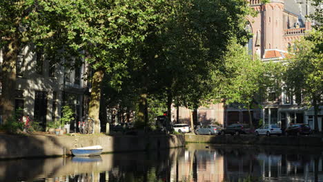 mirror reflections over river canal near gouwekerk church in gouda, netherlands