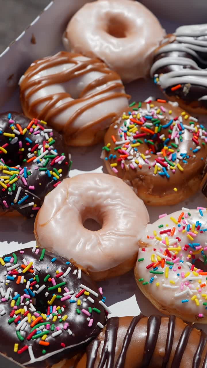 Assortimento di deliziose ciambelle glassate e con granella in una scatola