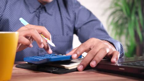 Person working on a laptop with calculator