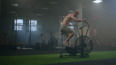 a man dominates an aerobics ride in the gym in slow motion. cardio training on a stationary bike
