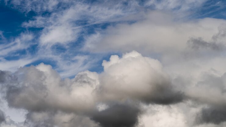 Cloud Time lapse with white fluffy mixing with dark angry clouds swirling around in blue sky