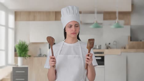 indian female professional chef posing with spoon and spatula