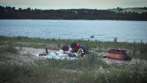 familia de 4k haciendo picnic junto al lago