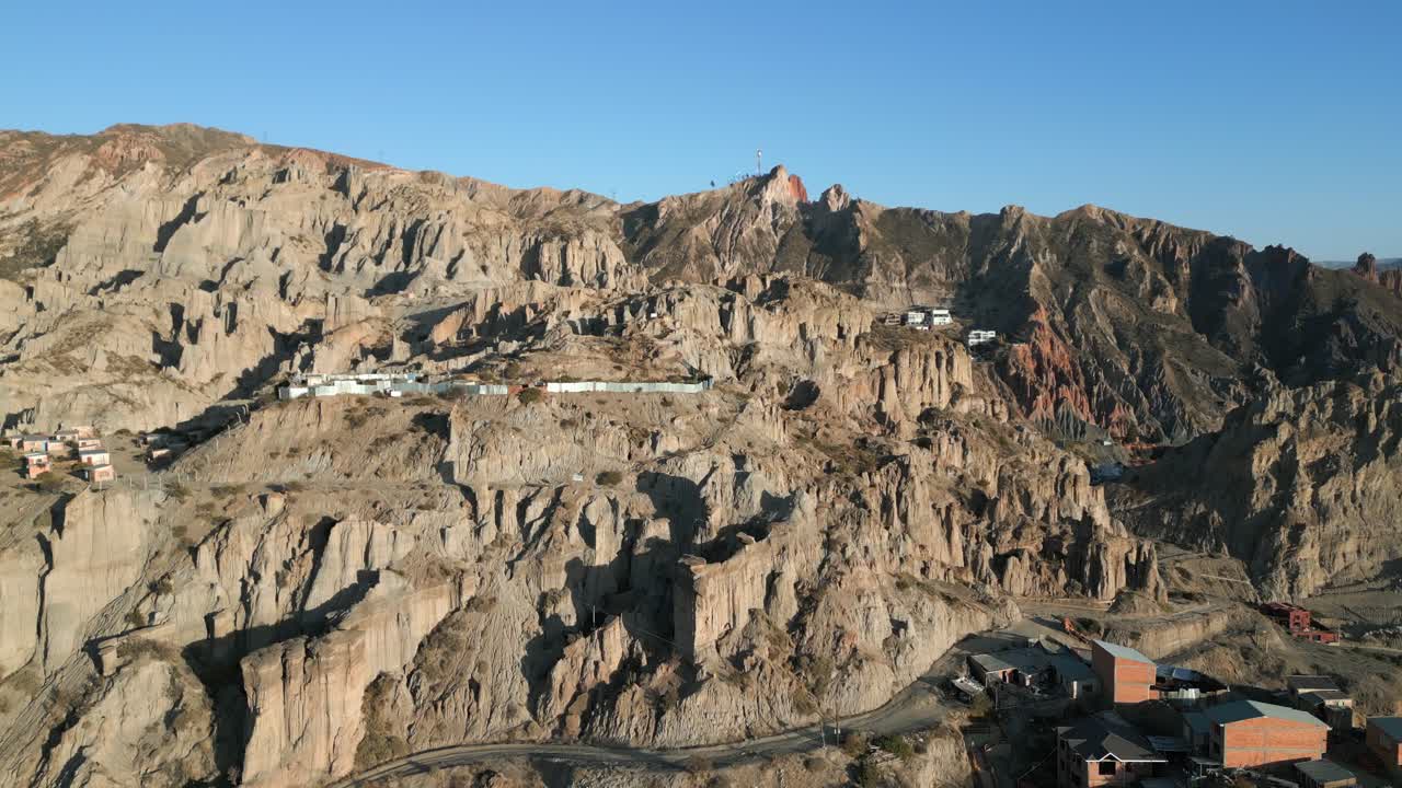 drone aéreo hacia adelante disparado sobre un pequeño pueblo a lo largo de terrazas en las laderas de la montaña con carreteras sinuosas durante la mañana