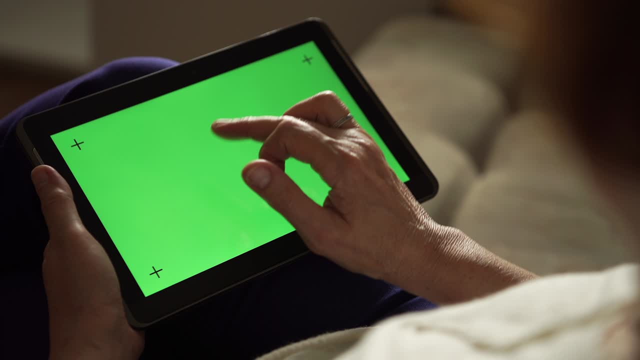 mujer anciana usando una tableta digital con pantalla verde, vista trasera
