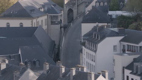 Elevated-view-of-a-tranquil-old-European-town-with-historical-architecture-and-a-stone-bridge