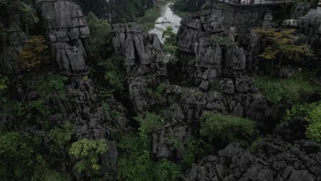 Drone-flying-through-mountain-tops-with-people-and-into-a-lake-in-the-valley-of-Nin-Bihn-in-Vietnam