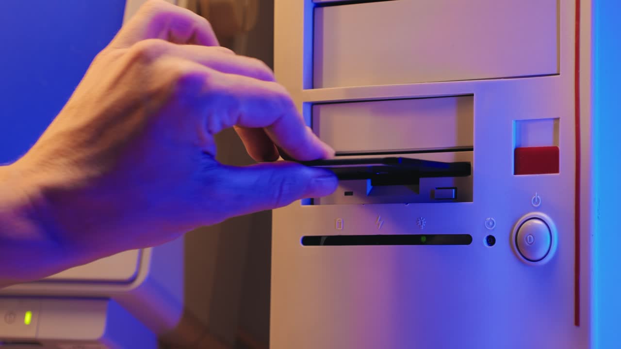 Using diskette for old computer. Music recorder, playing retro computer games. Vintage device for office, obsolete technology. . High quality 4k footage